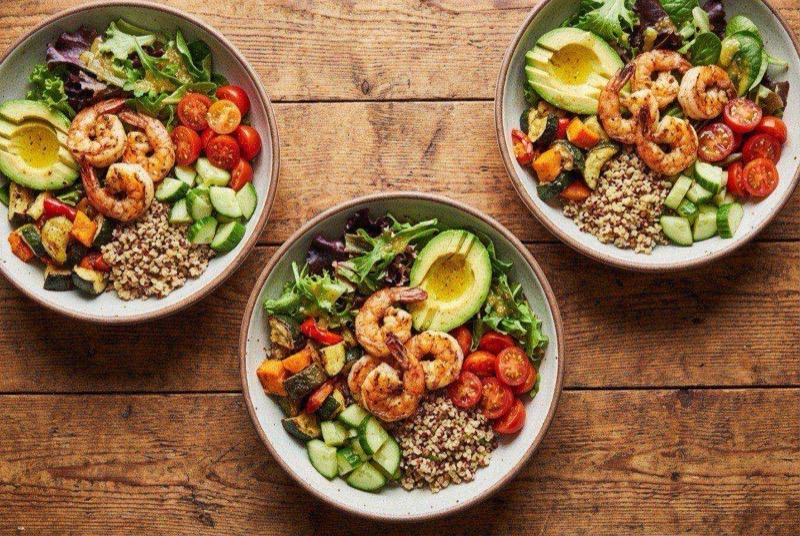 Grilled shrimp on a bed of mixed greens with quinoa, corn, avocado, and cherry tomatoes