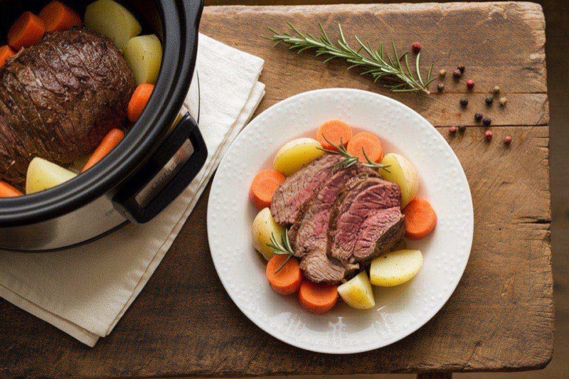 Fork-tender pot roast pulled apart showing juicy meat fibers with carrots and potatoes